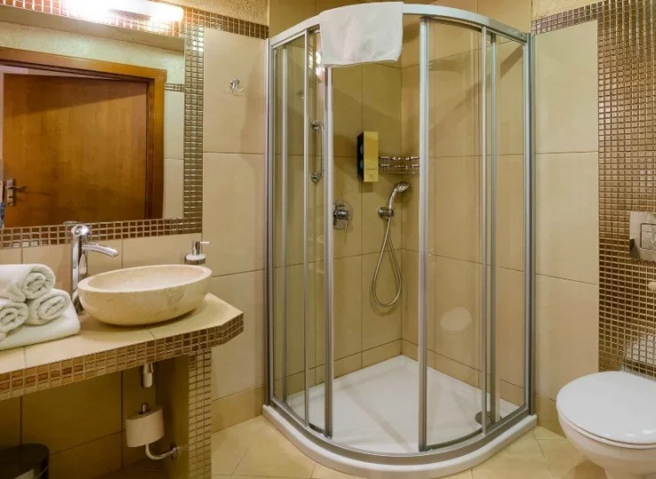 W łazience jest kabina prysznicowa, komplet ręczników i suszarka do włosów
