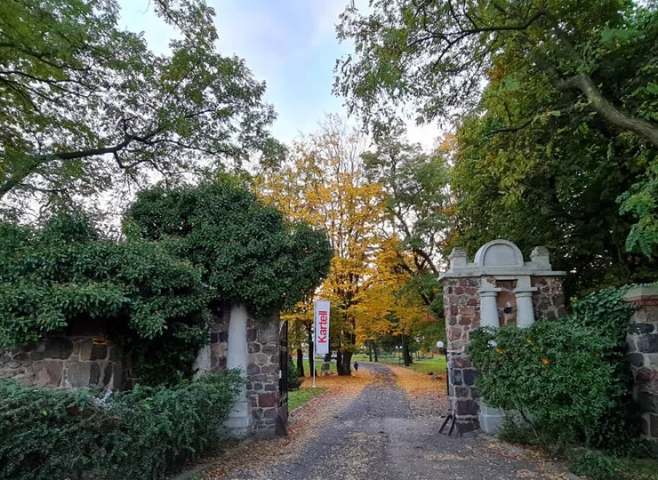 Do obiektu prowadzi zabytkowa brama i droga przez park