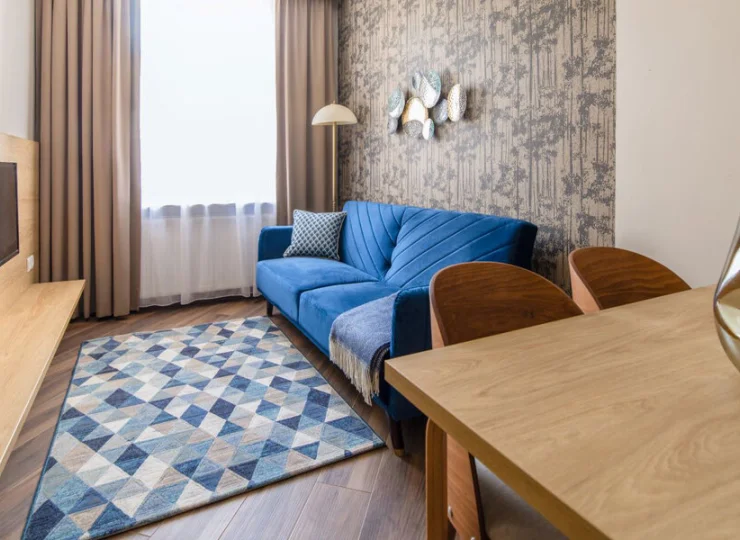 Apartament junior posiada salon z rozkładaną sofą, kącikiem jadalnym i TV