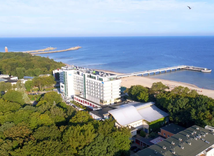 Budynek jest otoczony zielenią Parku Zdrojowego i plażą