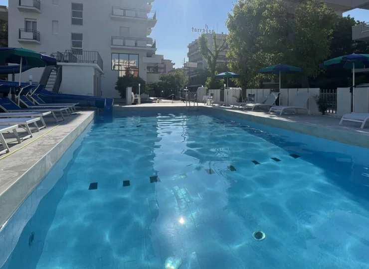 Hotel oferuje odnowiony zewnętrzny basen z leżakami i parasolami