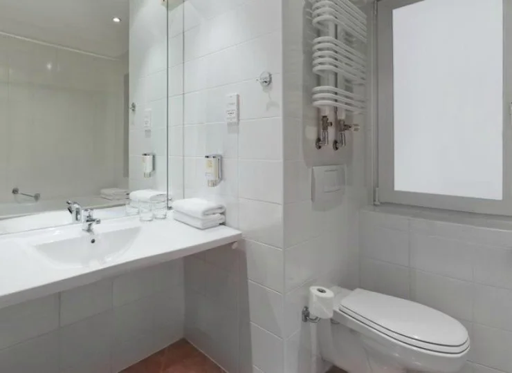W łazience znajduje się kabina prysznicowa, suszarka do włosów