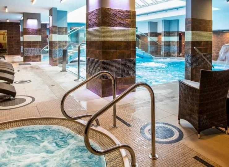 Obok basenu są leżaki i jacuzzi