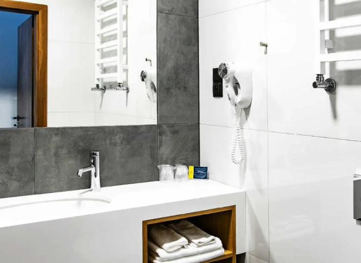 W łazience: kabina prysznicowa, suszarka do włosów i ręczniki