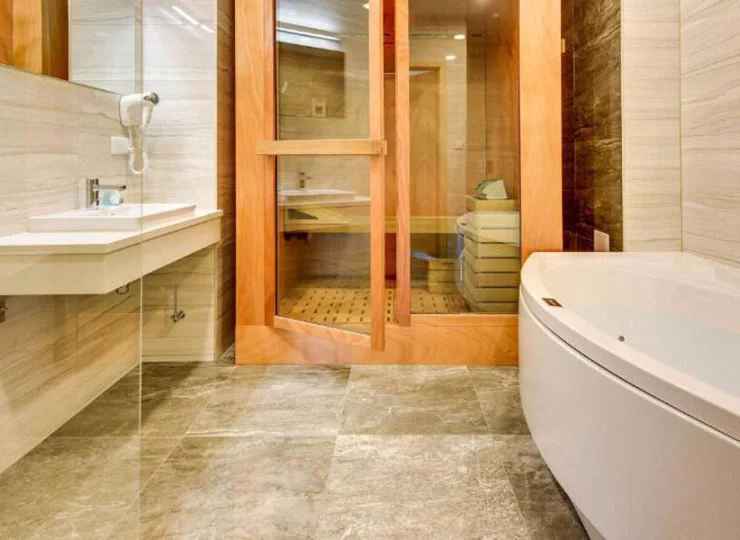 Wanna z hydromasażem, sauna oraz kabina prysznicowa w salonie kąpielowym