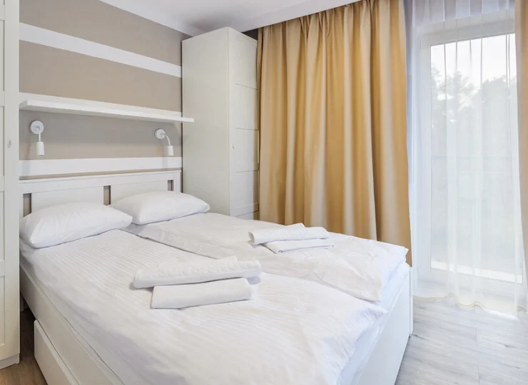Sypialnia posiada podwójne łóżko i szafę lub szafki