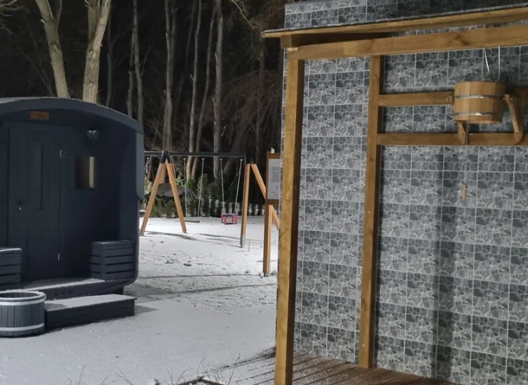 Obok domku saunowego zainstalowano orzeźwiający zewnętrzny prysznic