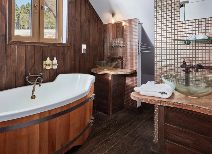 Nowoczesna łazienka zawiera wannę (drewnianą balię lub standardową wannę)