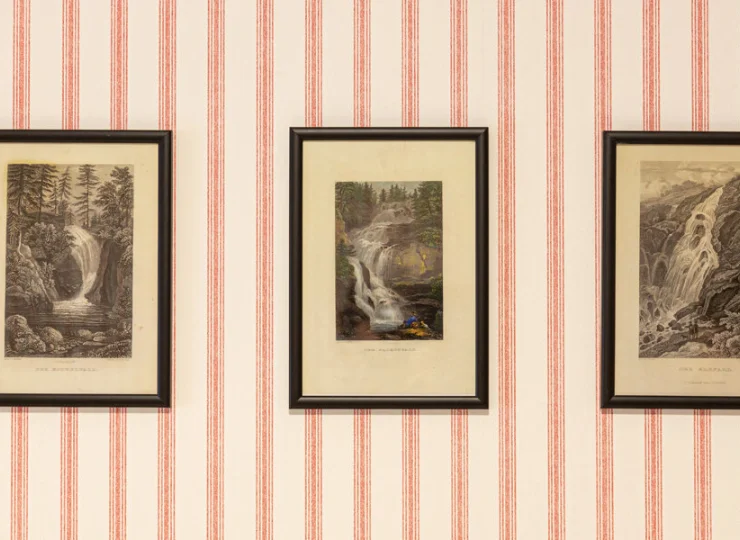 Ściany pokoju deluxe zdobią archiwalne grafiki przedstawiające cuda okolicy