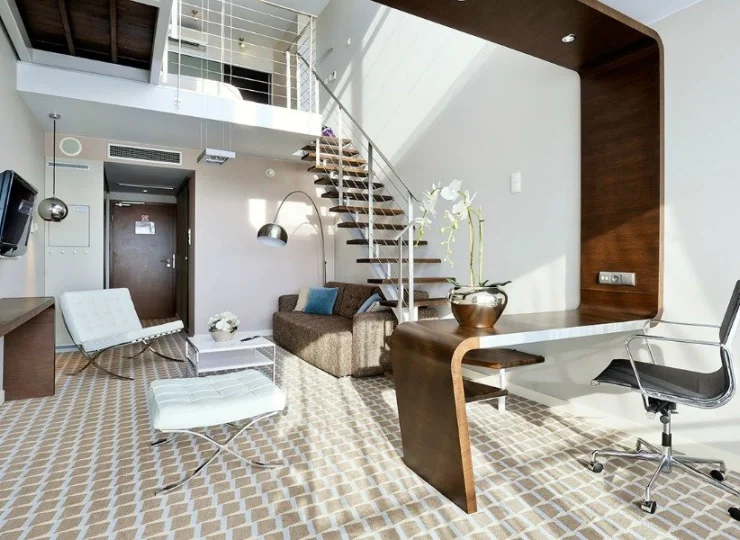 Apartament Lux posiada sypialnię na antresoli i dwuosobową kanapę w salonie