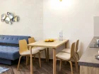 Apartament junior posiada salon z rozkładaną sofą, kącikiem jadalnym i TV