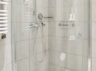 W łazience znajduje się kabina prysznicowa i suszarka do włosów