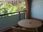 Balkon z wiklinowymi meblami i widokiem na bujny ogród