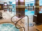 Obok basenu są leżaki i jacuzzi