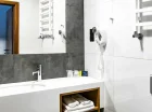 W łazience: kabina prysznicowa, suszarka do włosów i ręczniki