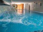 Jest tutaj kryty basen z podgrzewaną wodą, przeciwprądem i wodospadem