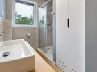 W łazience znajduje się kabina prysznicowa oraz pralka