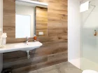 Nowoczesna łazienka jest wyposażona w kabinę prysznicową i suszarkę do włosów