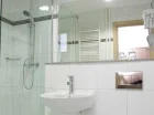 W łazienkach: kabina prysznicowa, suszarka do włosów, ręczniki i kosmetyki