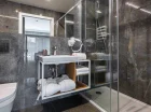 Nowoczesna łazienka zawiera przestronną kabinę prysznicową