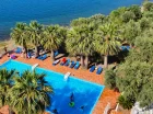 Hotel posiada sezonowy zewnętrzny basen z leżakami otoczony palmami