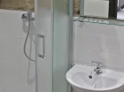 W łazience jest pełen węzeł sanitarny z kabiną prysznicową
