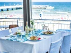Z okien restauracji rozpościera się widok na plażę i morze