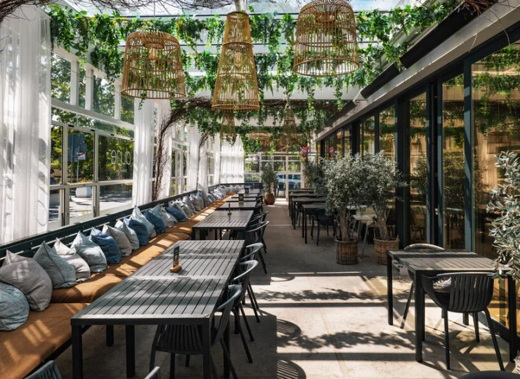 Restauracyjny taras jest przyjemnym miejscem skąpanym w zieleni
