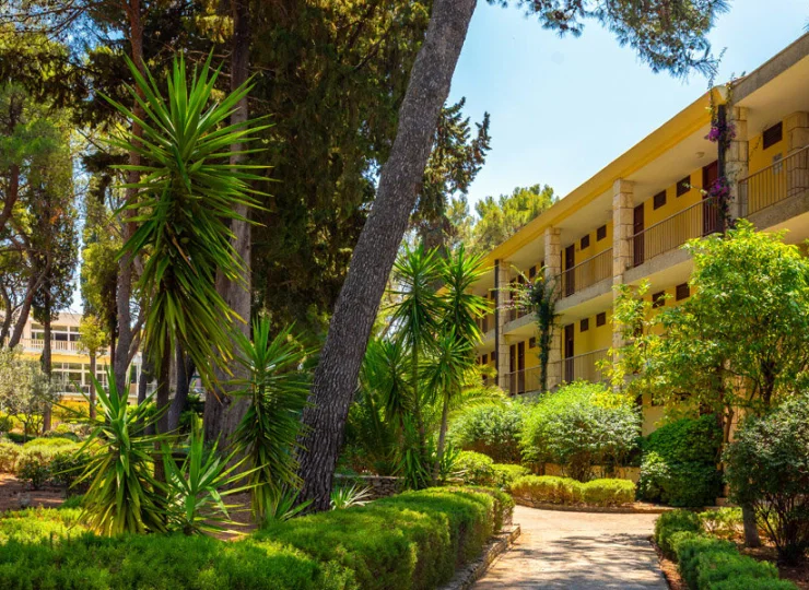 Dwa budynki hotelowe są otoczone śródziemnomorskim ogrodem