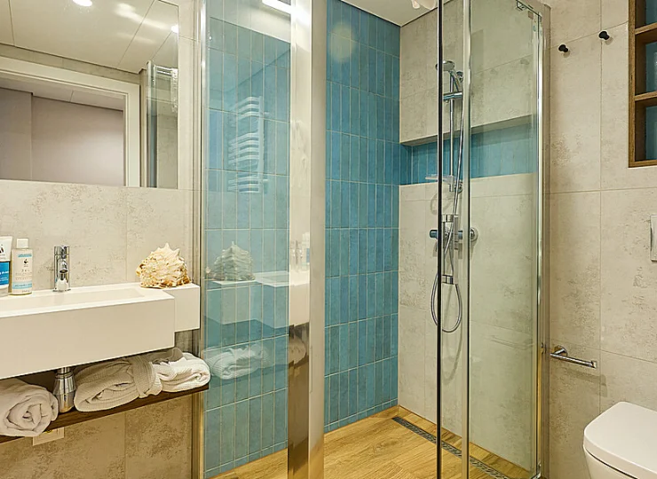 W łazienkach jest kabina prysznicowa, suszarka do włosów, kosmetyki