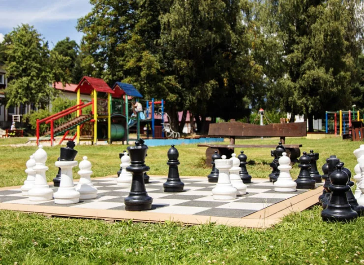 Wielkie szachy obok placu zabaw