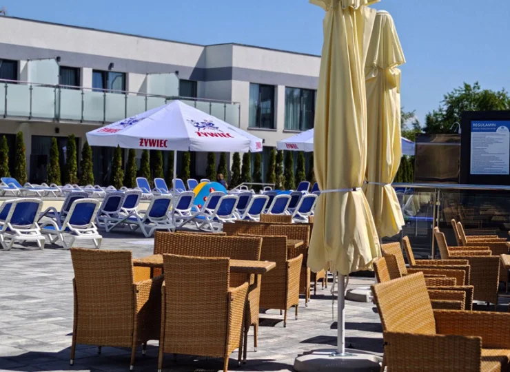 Nieopodal basenu są też stoliki z parasolami