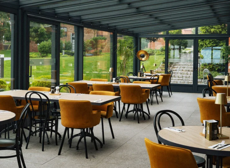 Część restauracyjnych stolików znajduje się na przyjemnym, zadaszonym tarasie