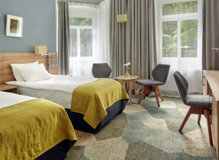 Duże okna zapraszają do pokoju zieleń uzdrowiska