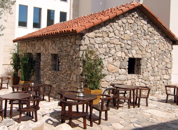 Stoliczki w otoczeniu tradycyjnego domu z kamieni