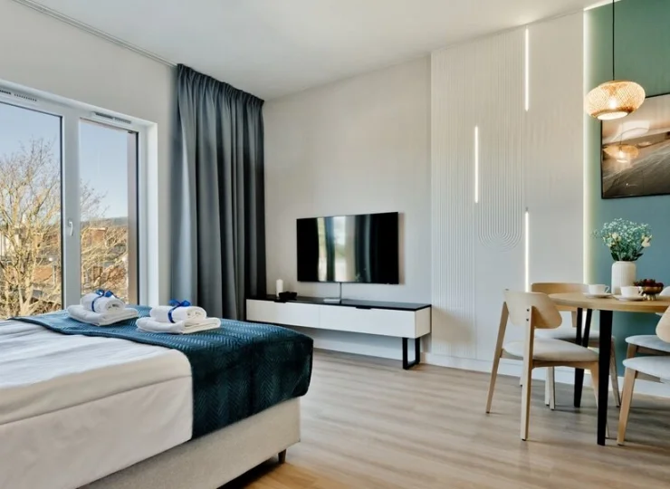 Ten apartament ma pokój z łóżkiem i aneksem kuchennym