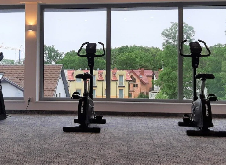 Przez przeszklone ściany siłowni widać nadmorski las