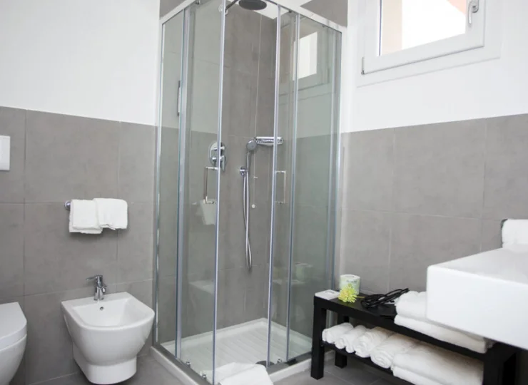 W łazience jest kabina prysznicowa, ręczniki, suszarka do włosów