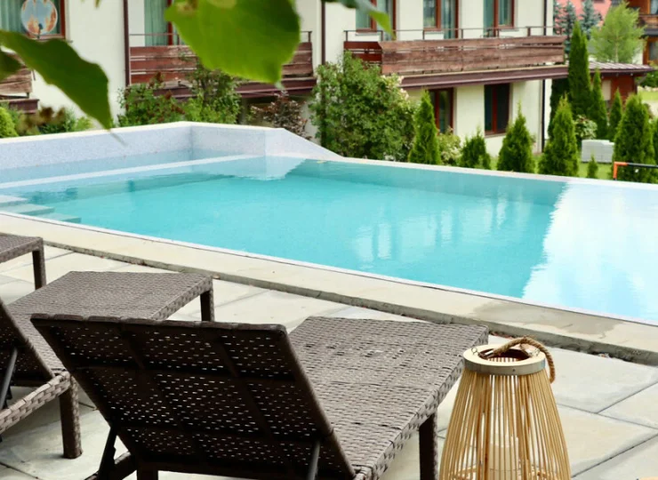 Przy basenie są ustawione stylowe leżaki