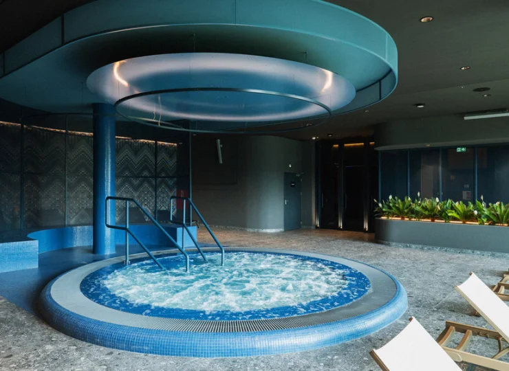 Obok jacuzzi są leżaki do relaksu z widokiem na góry