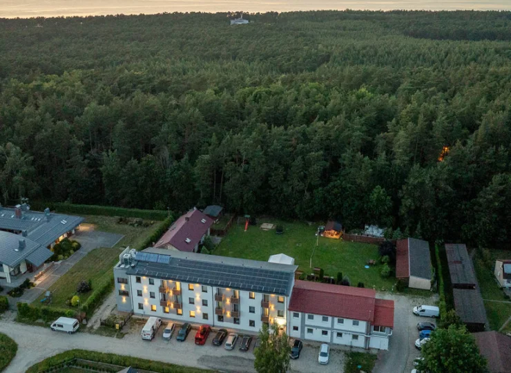 Od plaży obiekt dzieli pas nadmorskiego lasu