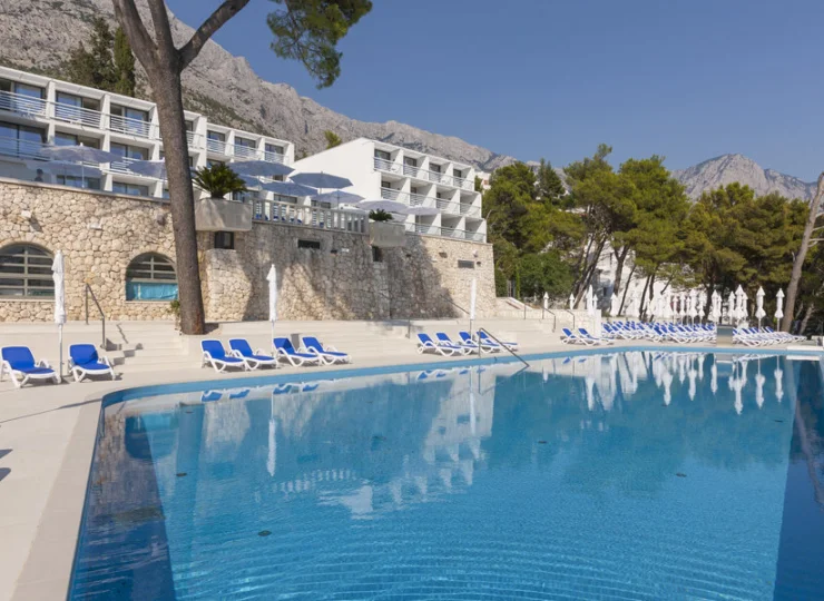 Przy basenach ustawiono leżaki oraz parasole