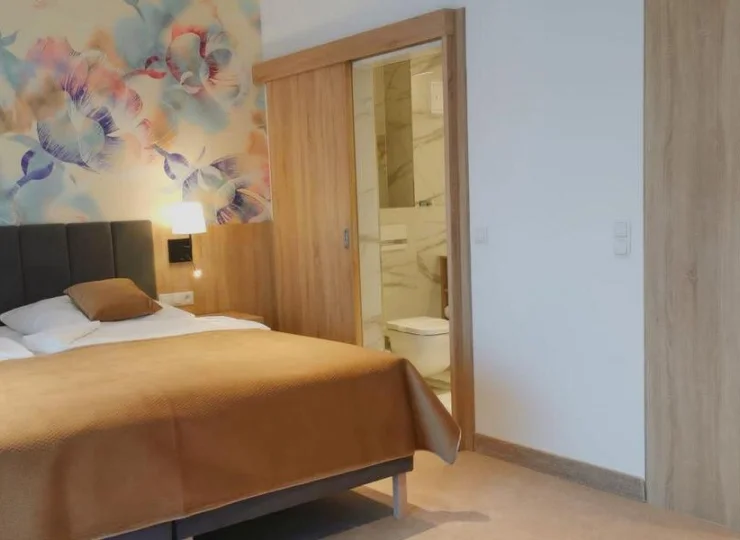 Pokoje LUX z aneksem dodatkowo wyposażono w płytę indukcyjną, lodówkę, zmywarkę