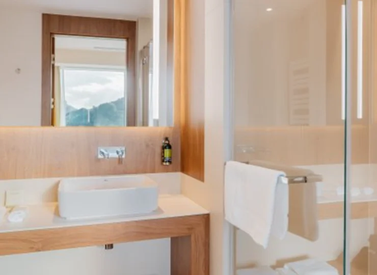 Łazienka z prysznicem, suszarką do włosów, ręcznikami i zestawem kosmetyków