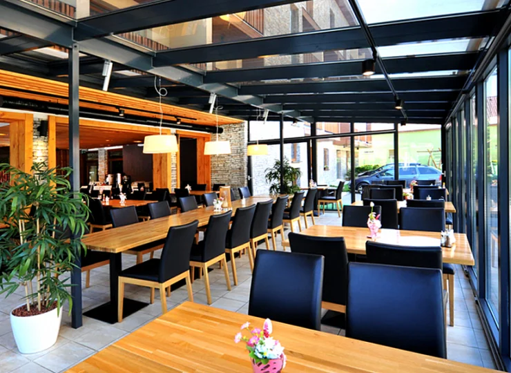 W restauracji jest przeszklony taras z widokiem na ogród