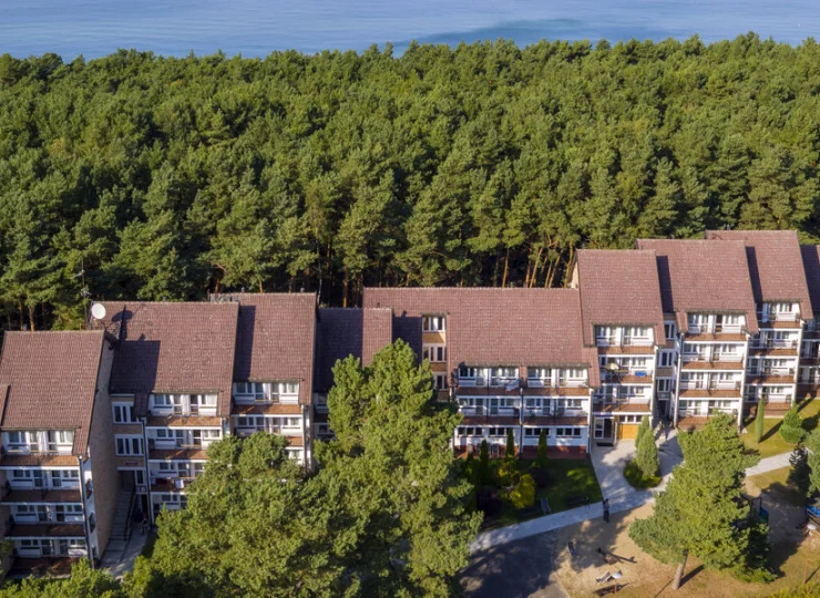 Od szerokiej piaszczystej plaży oddziela go tylko pas sosnowego lasu