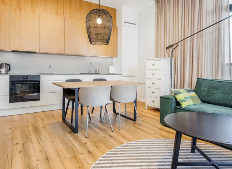 Funkcjonalny pokój dzienny z rozkładaną sofą, kącikiem jadalnianym i kuchnią