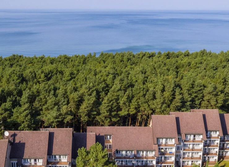 Od szerokiej piaszczystej plaży oddziela go tylko pas sosnowego lasu