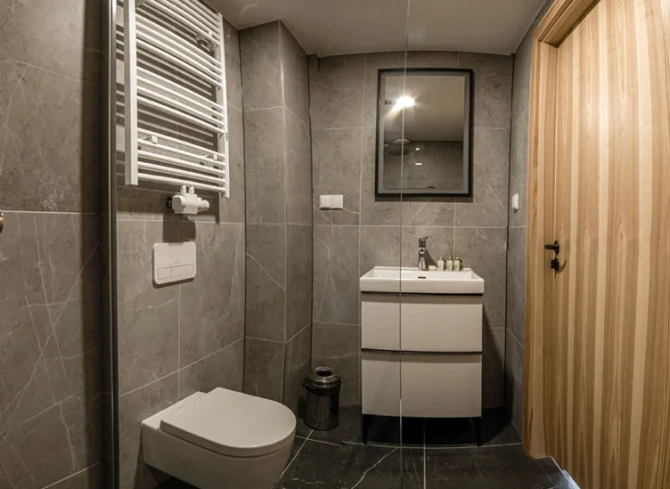 W łazience jest kabina prysznicowa i suszarka do włosów