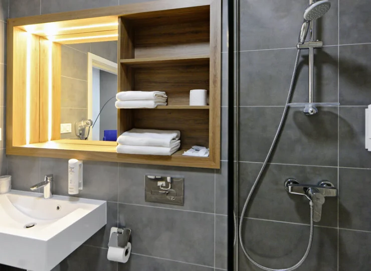 W łazience jest kabina prysznicowa, suszarka do włosów i kosmetyki